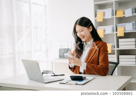 Asian businesswoman working in the office with working notepad, tablet and laptop documents in office Asian businesswoman working in the office with working notepad, tablet and laptop documents in office 103508801