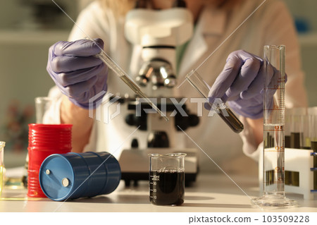 Chemist examines properties of crude oil using microscope Chemist examines properties of crude oil using microscope 103509228