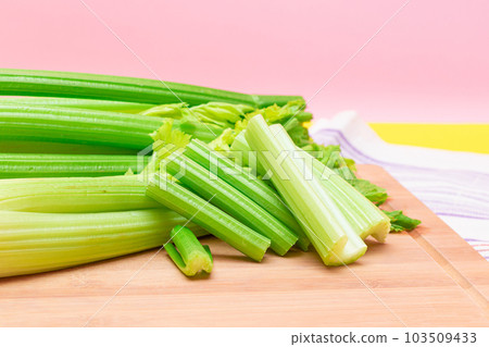 Fresh Celery Stem and Chopped Celery Sticks on Wooden Cutting Board 103509433
