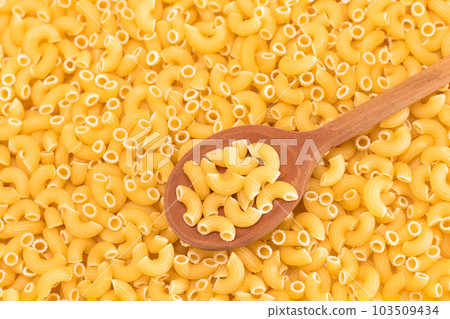 Uncooked Chifferi Rigati Pasta Background with Wooden Spoon Uncooked Chifferi Rigati Pasta Background with Wooden Spoon 103509434