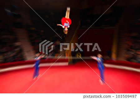 Abstract blurred image of tour of circus. Performance of acrobats on poles on arena in defocus Abstract blurred image of tour of circus. Performance of acrobats on poles on arena in defocus 103509497