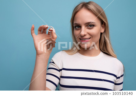 close-up photo of joyful happy young woman showing off buying real estate holding keychain of keys 103510140