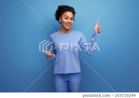 confident pretty brunette lady with afro curls showing super hand gesture on blue background with confident pretty brunette lady with afro curls showing super hand gesture on blue background with 103510244