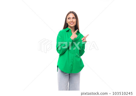 pretty young brown-haired female model with brown eyes in a green shirt points with her hands at the 103510245
