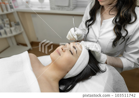 A medical worker demonstrates a medical procedure for deep cleansing of the skin face, which not only provides woman with effective care, but also provides opportunity to relax and relax luxuriously. 103511742