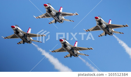 Four F-16 usaf Thunderbirds flying in the diamond formation with a blue sky Four F-16 usaf Thunderbirds flying in the diamond formation with a blue sky 103512384