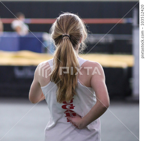 Female high jumper with a blurred background 103512420