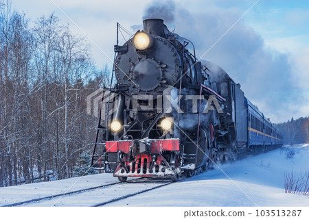 Retro steam train moves at winter morning time. 103513287
