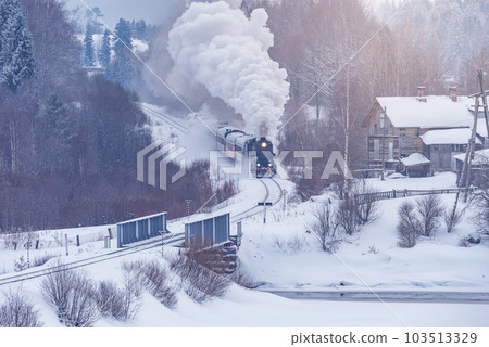Retro steam train moves at winter day. Retro steam train moves at winter day. 103513329