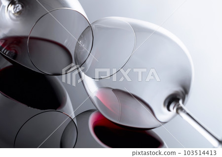 Glasses of red wine on a black reflective background. Glasses of red wine on a black reflective background. 103514413