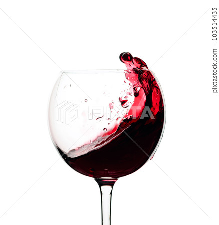 Splash of red wine in a glass isolated on white. Splash of red wine in a glass isolated on white. 103514435