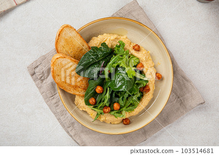 Portion of hummus with greens and toasts Portion of hummus with greens and toasts 103514681