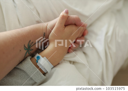 Husband holding woman's hand in hospital Husband holding woman's hand in hospital 103515975