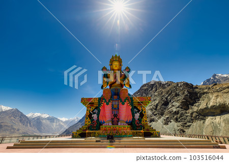 Big Sitting Buddha Statue at Diskit Monastery with Himalaya Range in the back - Nubra Valley, Ladakh, India. 103516044