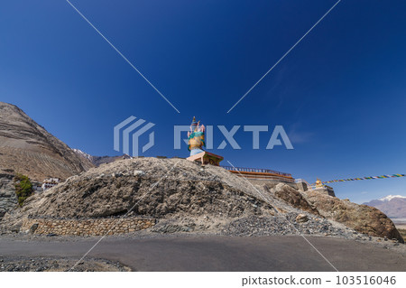 Big Sitting Buddha Statue at Diskit Monastery with Himalaya Range in the back - Nubra Valley, Ladakh, India. 103516046