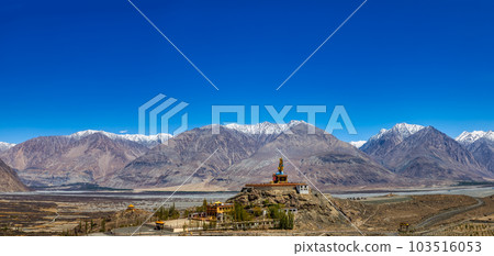 Big Sitting Buddha Statue at Diskit Monastery with Himalaya Range in the back - Nubra Valley, Ladakh, India. 103516053
