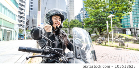 A female rider touring Yokohama on a cruiser bike fist pump A female rider touring Yokohama on a cruiser bike fist pump 103518623