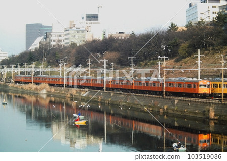 1983 年 1 月 16 日，一輛橙色的 103 系列火車在昭和市谷附近行駛，在總武中央站停靠。 103519086