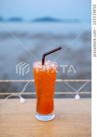 A glass of Mai Tai, a cocktail made of rum on the table with view of the beach A glass of Mai Tai, a cocktail made of rum on the table with view of the beach 103519650