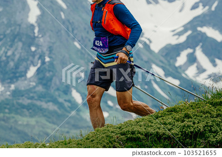 athlete running skyrunning marathon race on green meadow in background snowy mountain, on shoulders camelbak athlete running skyrunning marathon race on green meadow in background snowy mountain, on shoulders camelbak 103521655