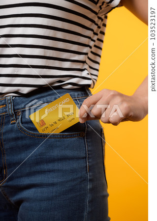 hand of person woman holding plastic credit card out of the pocket blue jean plants isolated on yellow studio background. online shopping payment, bill, currency, pay money, finance concept. hand of person woman holding plastic credit card out of the pocket blue jean plants isolated on yellow studio background. online shopping payment, bill, currency, pay money, finance concept. 103523197