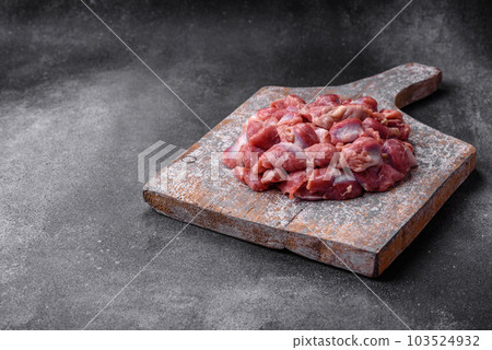 Raw chicken or turkey gizzards with salt, spices and herbs 103524932