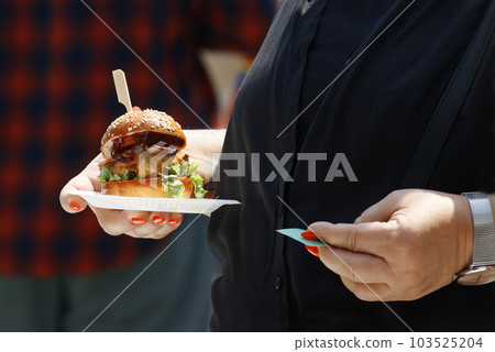 Buying hamburgers at street food market Buying hamburgers at street food market 103525204