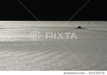 A fishing boat navigating Lake Biwa at dusk 103526579