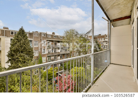 a balcony with some trees and buildings in the background, taken from an apartment building's window sie 103526587