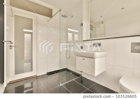 a modern bathroom with black and white tile flooring, glass shower stall door and toilet in the corner area a modern bathroom with black and white tile flooring, glass shower stall door and toilet in the corner area 103526605