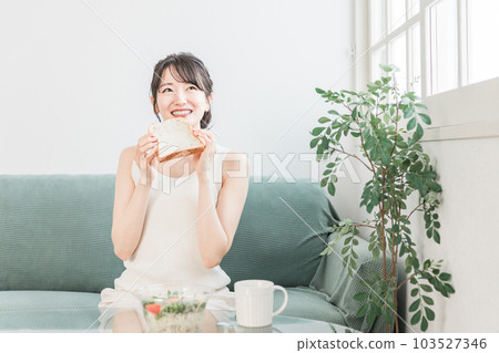 微笑的亞洲女人早餐吃麵包和沙拉 微笑的亞洲女人早餐吃麵包和沙拉 103527346