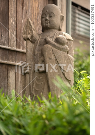 Jizo standing alone in a town 103527491