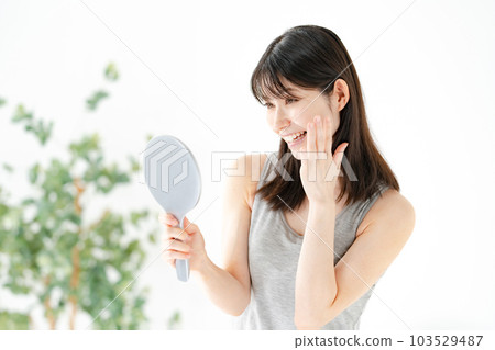 A woman looking at the mirror with a smile Beauty A woman looking at the mirror with a smile Beauty 103529487