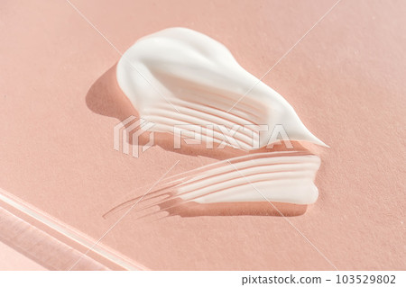 The texture of the white cream on a pink background. The texture of the white cream on a pink background. 103529802