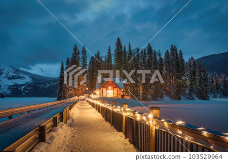 Emerald Lake with wooden lodge glowing in snowy pine forest on winter at Yoho national park 103529964
