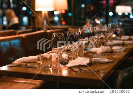 Restaurant long dining table setting with silverware and wineglass for catering Restaurant long dining table setting with silverware and wineglass for catering 103530022