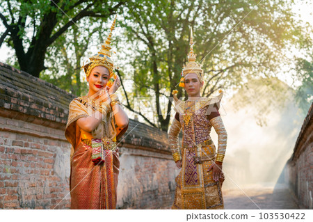 Portrait of Asian man and woman with Thai traditional dress stand together in front of ancient wall Portrait of Asian man and woman with Thai traditional dress stand together in front of ancient wall 103530422