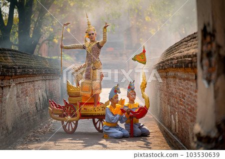Asian man with old Thai traditional cloth hold weapon and stand and action of dance on chariot 103530639