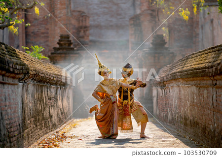 Beautiful Asian woman wear Thai traditional dress action of dancing together with Thai classic mask 103530709