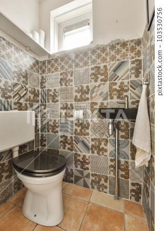 a bathroom with tiles on the wall and toilet in the corner, which has been used for many years to make it look like 103530756