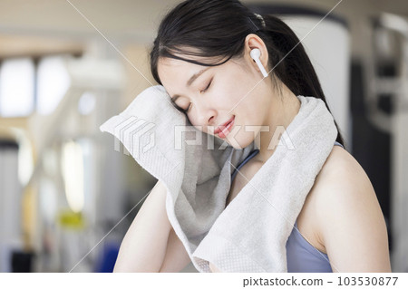 Young woman wiping sweat at the gym 103530877