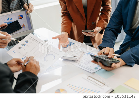 Businessman and team analyzing financial statement Finance task. with smart phone and laptop and  tablet. Wealth management concept. 103531142