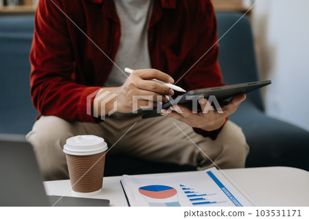 Businessman sitting front tablet ,laptop computer with financial graphs and statistics on monitor.at office 103531171