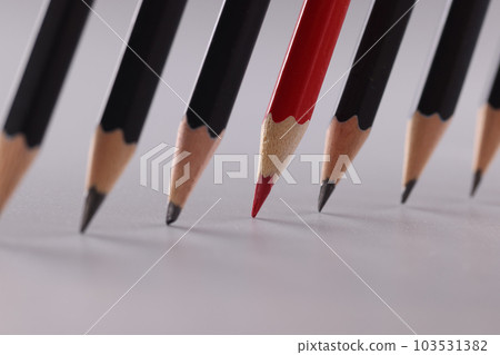 One red pencil and many black pencils closeup One red pencil and many black pencils closeup 103531382