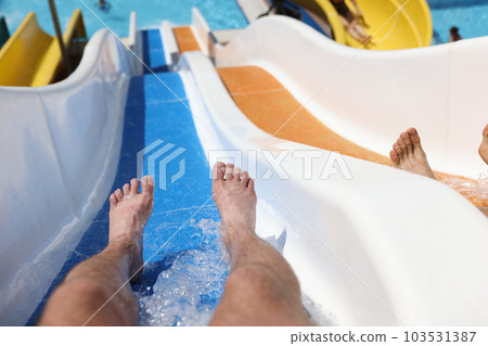 Man has fun on water slide in water park closeup Man has fun on water slide in water park closeup 103531387