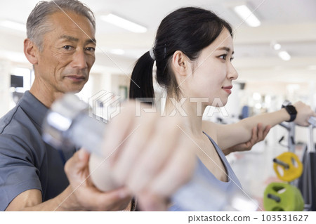 Young woman training with a personal trainer at the fitness gym Young woman training with a personal trainer at the fitness gym 103531627