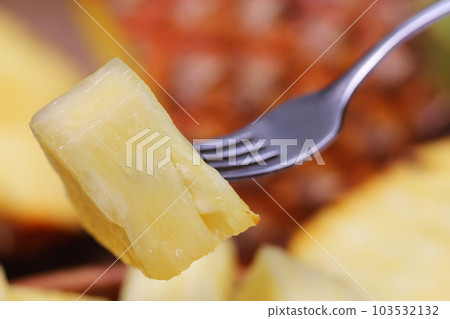 Macro of sliced pineapple with fork Macro of sliced pineapple with fork 103532132