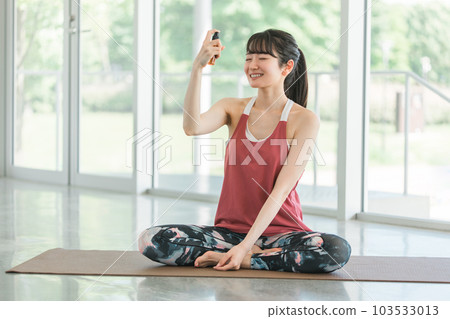 Woman doing yoga and using face mist, face spray, cologne spray 103533013