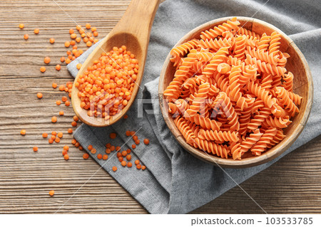 Fusilli red lentil pasta on a old wooden background. Fusilli red lentil pasta on a old wooden background. 103533785
