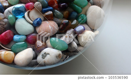 Round glass sphere with colored glass stones on a sea rocks inside Round glass sphere with colored glass stones on a sea rocks inside 103536590